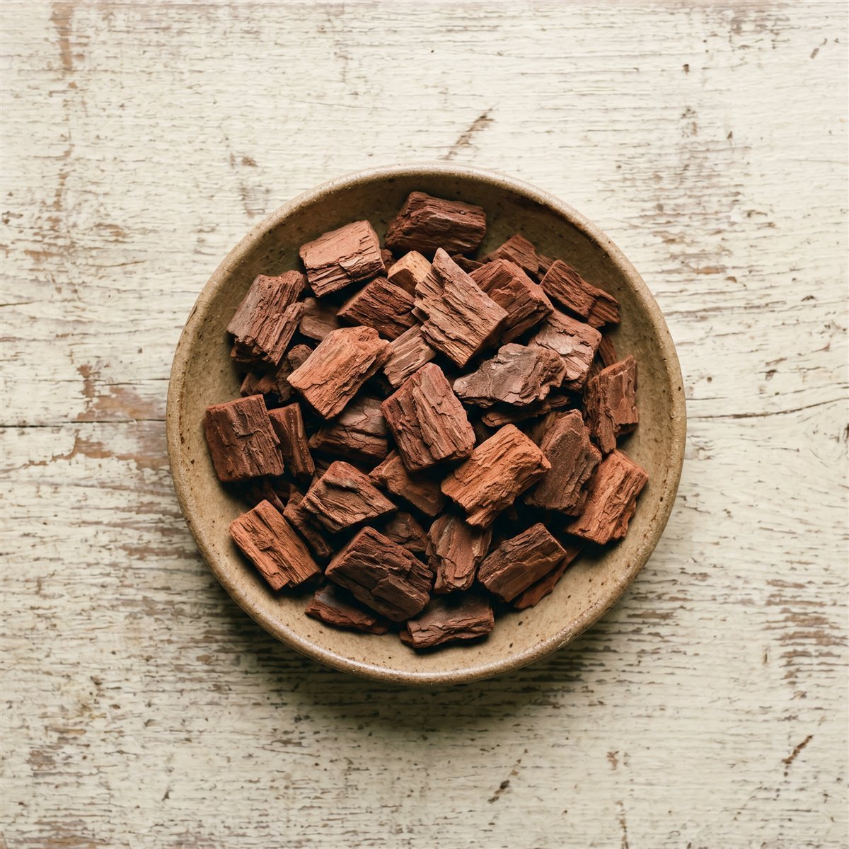 Graded fir orchid bark chunks in a bowl on a weathered wood surface
